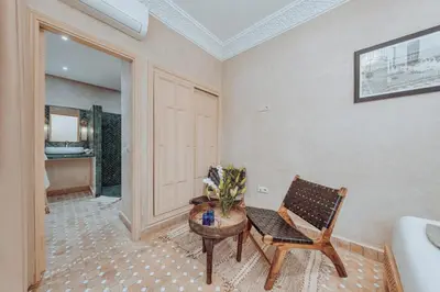 a room with a chair and a table with flowers at Riad Valentine in Marrakech