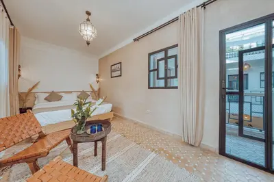 a room with a bed and a couch and a window at Riad Valentine in Marrakech