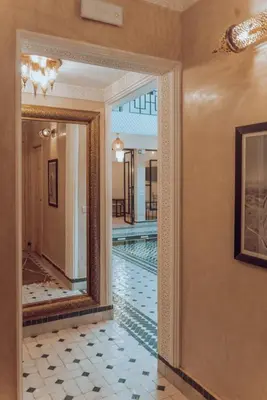 a hallway with a mirror and a swimming pool at Riad Valentine in Marrakech