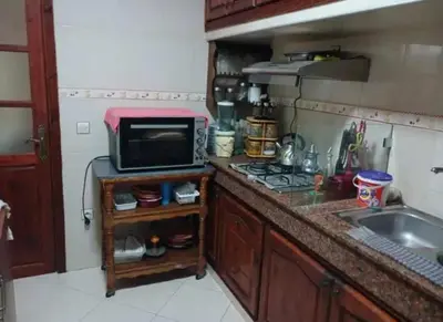 a small kitchen with a microwave and a sink at appartement meuble in Marrakech