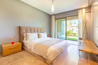 a bedroom with a large bed and a large window at Waterfront - Garden Level - Prestigia in Marrakech