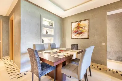 a dining room with a wooden table and chairs at Waterfront - Garden Level - Prestigia in Marrakech