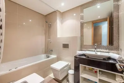 a bathroom with a sink and a tub and a toilet at Waterfront - Garden Level - Prestigia in Marrakech