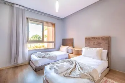 a bedroom with two beds and a window at Waterfront - Garden Level - Prestigia in Marrakech