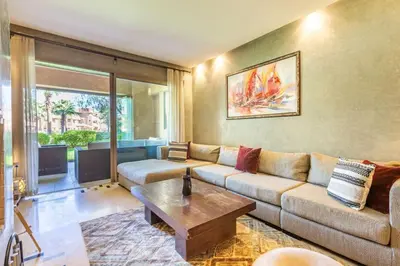 a living room with a couch and a coffee table at Waterfront - Garden Level - Prestigia in Marrakech