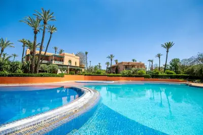 a swimming pool in a resort with palm trees at Luxe et Detente Haut standing Piscine in Marrakech