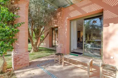 a house with a bench in front of a building at Luxe et Detente Haut standing Piscine in Marrakech