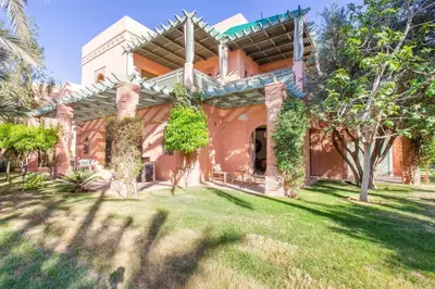 a large orange house with trees in the yard at Luxe et Detente Haut standing Piscine in Marrakech
