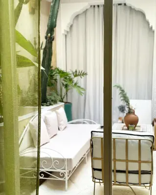 a room with a bed and a table and a window at Riad Dar Chalyia, private, 6 people, pool in Marrakech