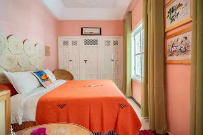a bedroom with a bed with an orange blanket at Riad Dar Chalyia, private, 6 people, pool in Marrakech