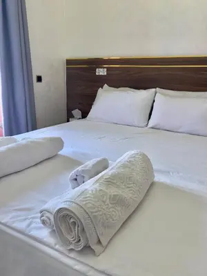 a white bed with two towels on it at Family Apartment in Marrakech in Marrakech