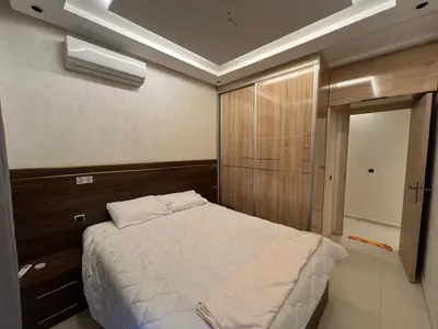 a bedroom with a white bed in a room at Family Apartment in Marrakech in Marrakech