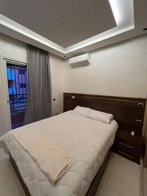 a bedroom with a bed in a room with a window at Family Apartment in Marrakech in Marrakech