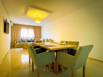 a dining room with a wooden table and chairs at Luxury Aprt 2 bedrooms Pool Hivernage City Centre in Marrakech