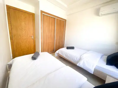 a bedroom with two beds and a wooden door at luxury Aprt2-bedrooms Pool hivernage heart of city in Marrakech