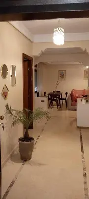 a living room with a potted plant in the middle at Appartement au cœur de Gueliz in Marrakech