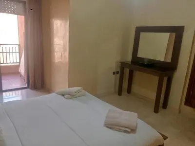 a bedroom with a bed with a mirror and a table at Appartement au cœur de Gueliz in Marrakech