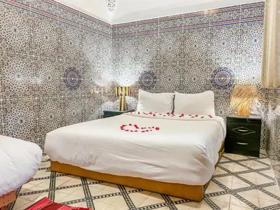 a bedroom with a bed with red roses on it at Riad Sifaw & Spa Marrakech in Marrakech