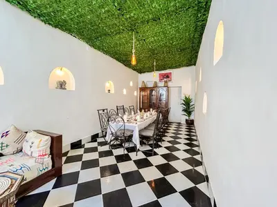a dining room with a table and a green ceiling at Riad Sifaw & Spa Marrakech in Marrakech