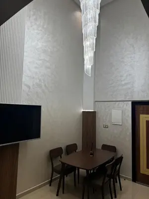 a dining room with a table and a flat screen tv at Super duplex in the middle of Marrakech in Marrakech