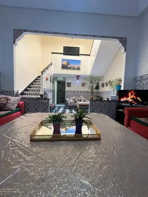 a living room with a table and a fireplace at Riad 49 G26 in Marrakech