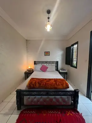 a bedroom with a large bed with a red blanket at Riad 49 G26 in Marrakech
