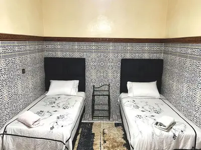 a room with two beds and a ladder at Maison de Vacances Idéale à 10 min de l'Aéroport in Marrakech