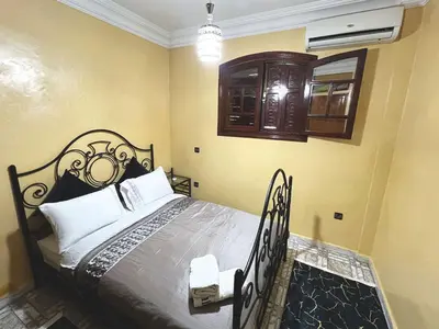 a bedroom with a bed with a wrought iron headboard at Maison de Vacances Idéale à 10 min de l'Aéroport in Marrakech