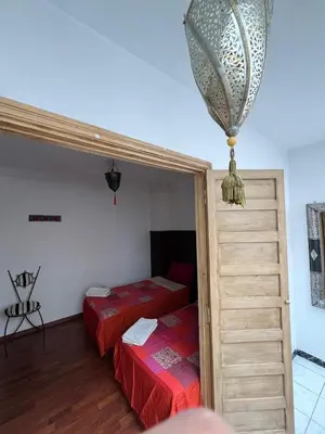 a room with two beds and a chandelier at LOGEMENT ENTIER MARRAKECh G4 N41 in Marrakech