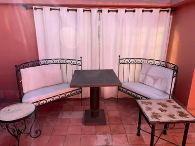 two chairs and a table in front of a window at LOGEMENT ENTIER MARRAKECh G4 N41 in Marrakech