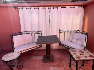 two chairs and a table in front of a window at LOGEMENT ENTIER MARRAKECh G4 N41 in Marrakech