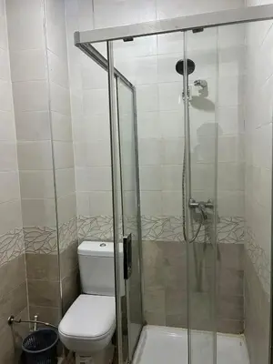 a bathroom with a toilet and a glass shower at Cozy Stay Close to Downtown in Marrakech