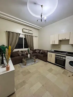a living room with a couch and a kitchen at Cozy Stay Close to Downtown in Marrakech