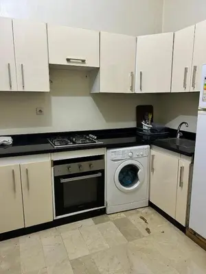a kitchen with white cabinets and a washing machine at Cozy Stay Close to Downtown in Marrakech