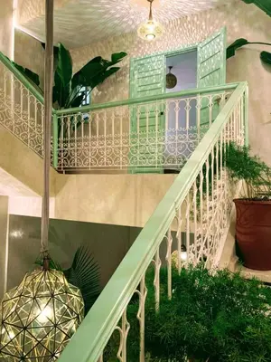 a white staircase with a green railing and plants at Riad with 3 Swimming Pools in Marrakech