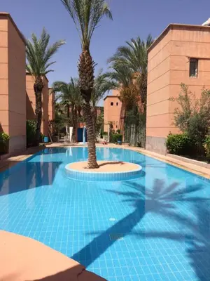 a large swimming pool with a palm tree in the middle at Riad with 3 Swimming Pools in Marrakech
