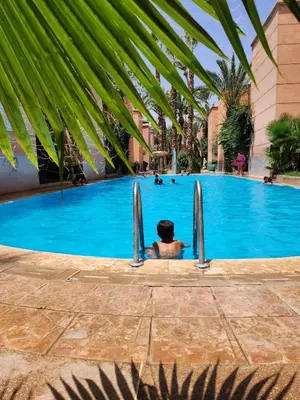 a person in a swimming pool at a resort at Riad with 3 Swimming Pools in Marrakech