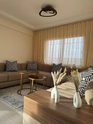 a living room with a couch and a table at KL Home- au cœur du centre ville moderne in Marrakech