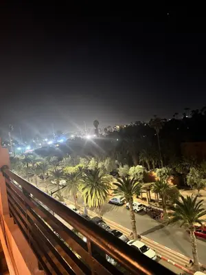 a view of a city at night with palm trees at KL Home- au cœur du centre ville moderne in Marrakech