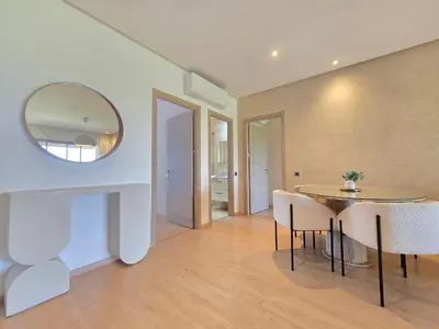 a dining room with a table and chairs and a mirror at Appartement Cosy - vue Piscine - Prestigia JADE in Marrakech