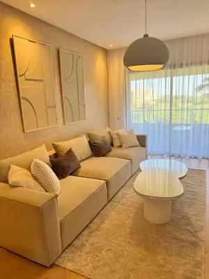 a living room with a couch and a table at Appartement Cosy - vue Piscine - Prestigia JADE in Marrakech