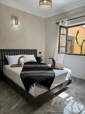 a bedroom with a bed with a black blanket and a window at Cozy, Intimate Villa in Marrakech with Heated Swimming Pool Option in Touggana