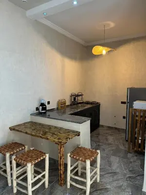 a kitchen with a table and two stools in a room at Cozy, Intimate Villa in Marrakech with Heated Swimming Pool Option in Touggana