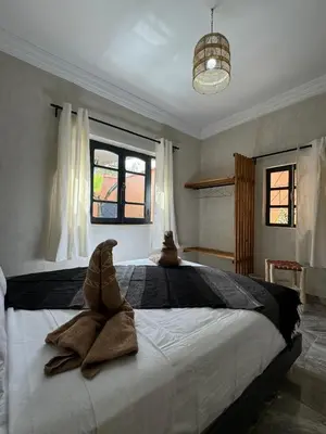 a bedroom with a large bed with towels on it at Cozy, Intimate Villa in Marrakech with Heated Swimming Pool Option in Touggana