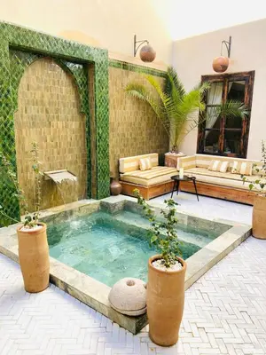 a pool in the middle of a patio with plants at Riad Al Scarabi in Marrakech