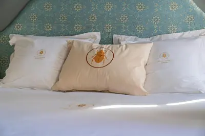 a bed with four pillows with a bee on it at Riad Al Scarabi in Marrakech
