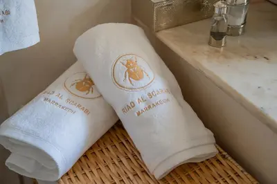 two towels sitting on a basket next to a sink at Riad Al Scarabi in Marrakech