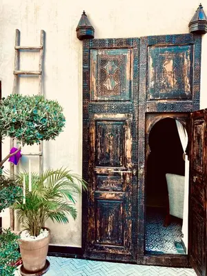 an old wooden door in a room with plants at Riad Al Scarabi in Marrakech
