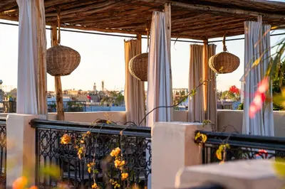 a balcony with a table and chairs and windows at Riad Al Scarabi in Marrakech