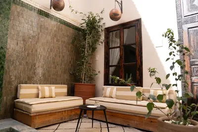 a patio with two couches and a window at Riad Al Scarabi in Marrakech